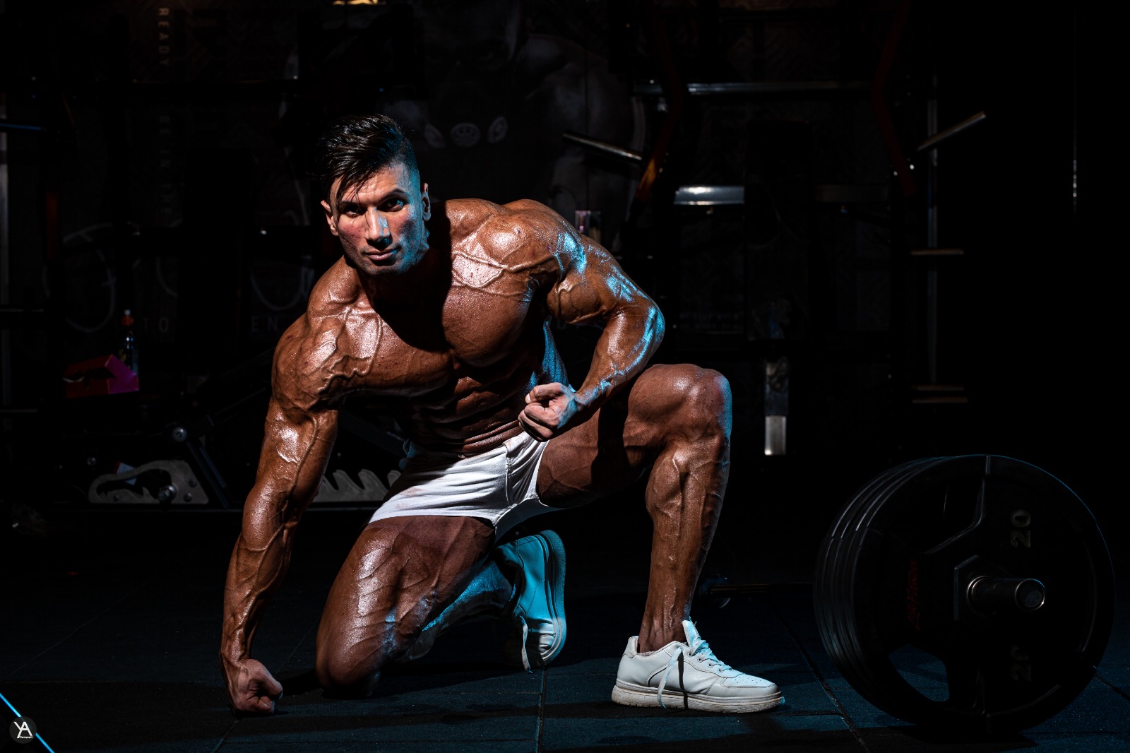 Adel kneeling low in a wide shot under hard light