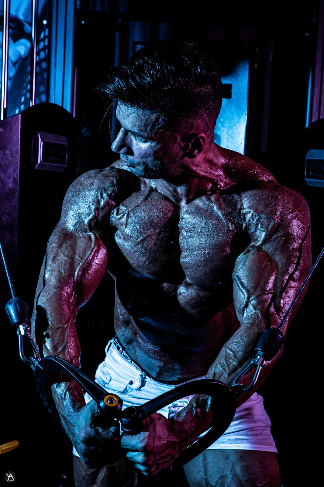 Adel mid-rep in a cable crossover, chest under tension